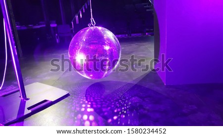 Silver Disco ball indoor. Pink and violet colored background. Recreation and Entertainment Concept. 