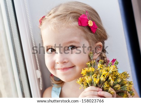cute little girl with dandelion flowers smiling looking at the camera on a white background