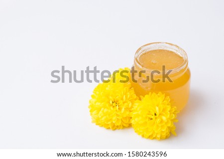 organic cosmetics jar with yellow flowers isolated on white background