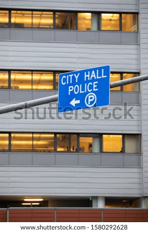 "City Hall and Police" sign, with an arrow for parking, at a local government building, with space for text on top and bottom
