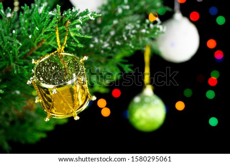Golden Christmas ornament hanging on Christmas tree. Colorful bokeh backgorund. Chrismas and New Year decoation.