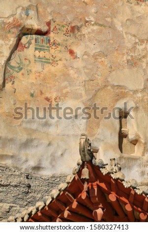 Upturned eaves on tiled roof with dragon figures-9 story high wooden porch of cave 96-Mogao Caves S.area with 492 caves and cell temples dating from centuries 4th to 14th. Dunhuang-Gansu prov.-China.