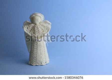 Beautiful knitted Christmas angel on blue background