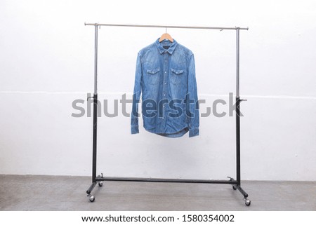 long sleeve blue jeans shirt on hanger-gray background
