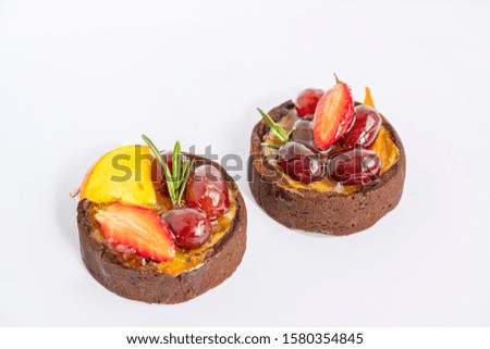 Two tasty colorful cakes with icing fruits and berries on white background, isolated and macro