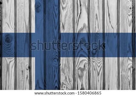 Finland flag depicted in bright paint colors on old wooden wall. Textured banner on rough background