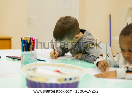 A multi-ethnic group of children in a school desk