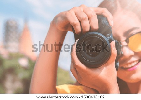 Young Asian girl with camera & taking photo of natural view