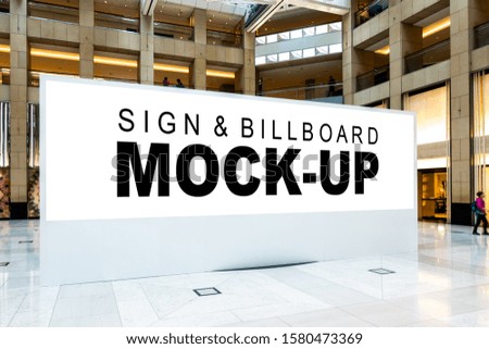 Mock up large blank horizontal billboard with clipping path standing on hall of building, blurred people walking, empty space for advertising or information media