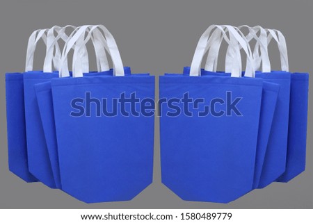 blue color shopping bags on gray background. environmentally concept. reusable shopping handbags 