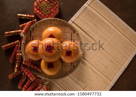 
Chinese knot luck, firecrackers and Chinese gold ingots and fresh orange on old wood table (Chinese means blessing, prosperity, wealth, spring, auspicious)