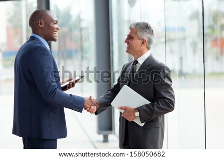 two cheerful businessman handshaking in conference hall Royalty-Free Stock Photo #158050682