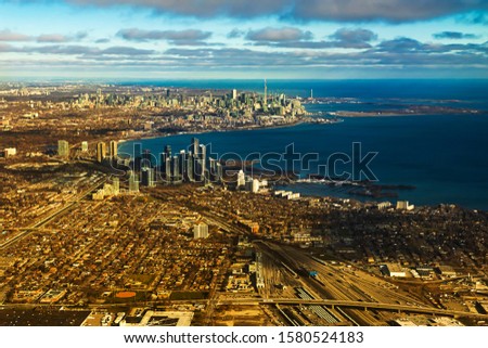 Panoramic aerial view of the city of Toronto and surrounding suburbs. Lake Ontario, blue and yellow tones, urban area. Skyline, cityscape,
