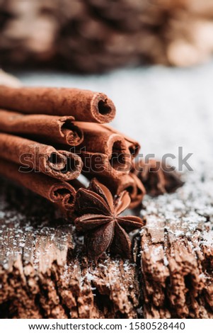 Christmas setting with bundle of cinnamon, anise stars and other christmas decorations on the rustic wooden background. Selective focus. Shallow depth of field.