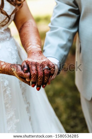 Wedding couple holding hands and bride wearing rings