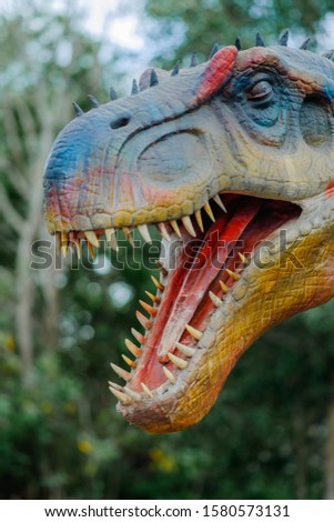 Head of dinasour with blurred  green as  background