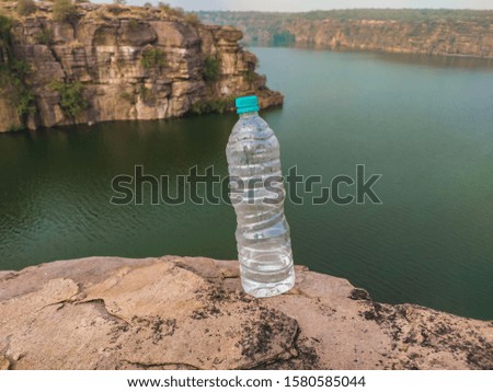 A picture of drinking water bottle at the bank of river or in the front of river  showing the inmportane of water