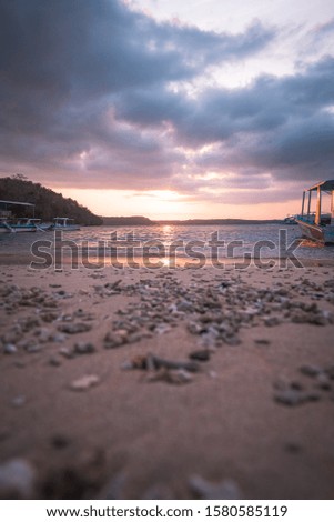 Sunset at the beach with stones in the picture