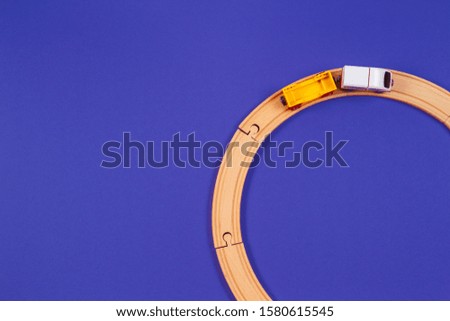 Toy train and wooden rails on blue color background