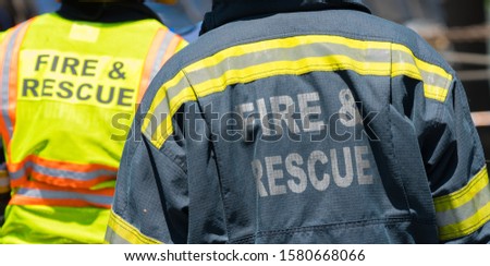 Fire and rescue personnel with their high visibility jackets at an accident scene concept emergency response people and assistance Royalty-Free Stock Photo #1580668066