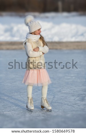 Girl on figure skates on a skating rink in  the park