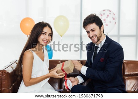 Young couple are wrapping a present together.