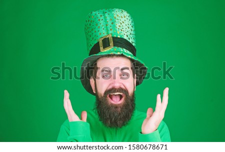 Clapping his hands with joy. Happy saint patricks day. Happy hipster in leprechaun hat and costume. Bearded man celebrating saint patricks day. Irish man with beard wearing green.
