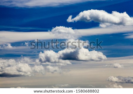 a beautiful blue sky lit with bright sunlight with white clouds of various shapes, a beautiful summer landscape
