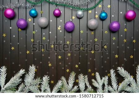 Colorful decorative background. Brown wooden plank table with green branches of Christmas tree, pine or fir and Christmas tree toys