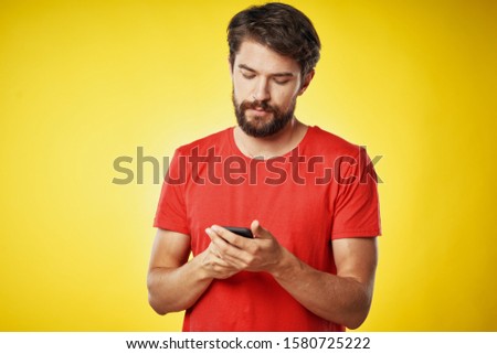 A man in a T-shirt smartphone is a device of communication providing services