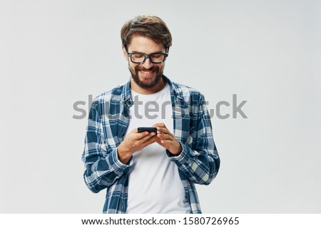 Man mobile phone unbuttoned shirt white t-shirt glasses