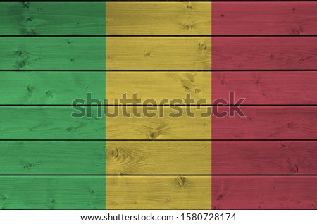 Mali flag depicted in bright paint colors on old wooden wall. Textured banner on rough background