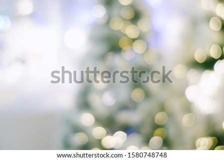 Abstract blurred Christmas tree decoration interior background with bokeh. Blurred festive mall/office background.