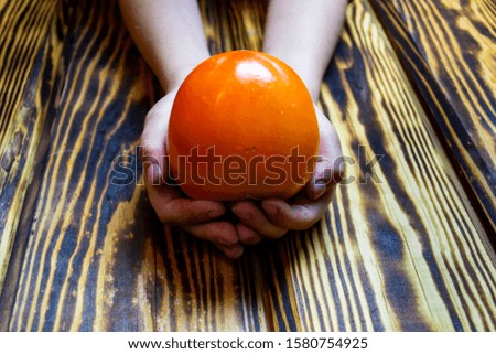 child's hands holding fresh fruits over the table, top view, selective focus