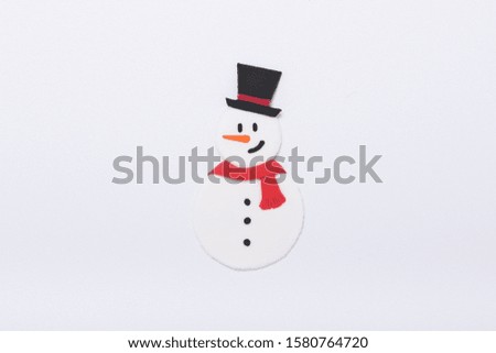 a handmade clay sculpture snowman wearing a red scarf and top hat on the white background