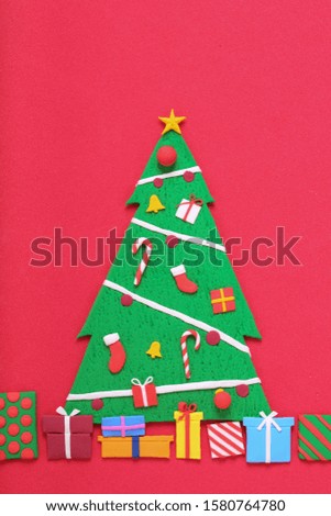 a handmade clay sculpture Christmas tree with ornaments and gift boxes