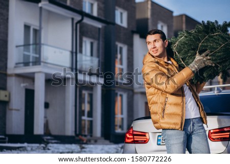 Father carrying christmas tree home