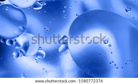 Oil drops in water. Defocused abstract psychedelic pattern image pastel colored. Blue toned. DOF
