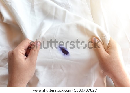 Dirty pen ink  stain on fabric from accident in daily life. Concept of cleaning stains on clothes or cleaning the house. Selected focus Royalty-Free Stock Photo #1580787829