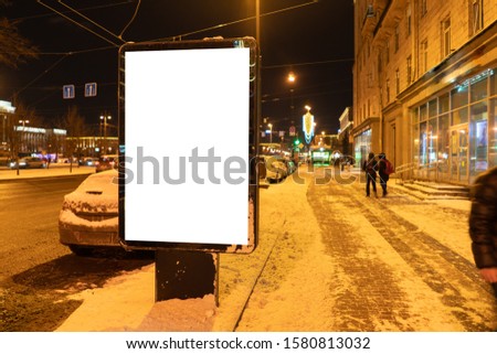 Vertical advertising city billboard format in winter in the city at night. Ad design MOCKUP with white field.