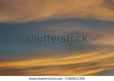 Blue sky hole that surrounding by glowing orange cloud in an evening