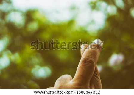 Men's hand made fingers crossed with natural bokeh, vintage style pictures            