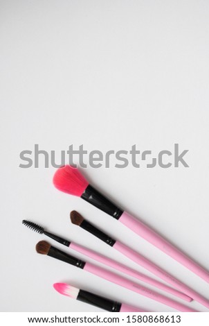 pink makeup brushes on white background