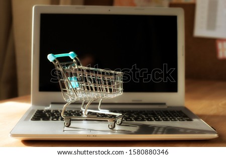 Shopping cart on laptop computer keyboard. Online shopping concept
