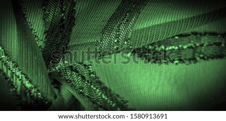 texture  background picture the fabric is transparent emerald green with brightly innate stripes, the material allowing the light to pass through it so that the objects behind are clearly visible.