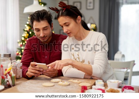 Couple with mobile phone in the kitchen 