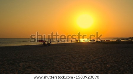 People on the beach at sunset.