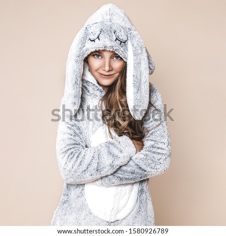Happy little kid wearing kigurumi pajamas at Christmas eve.Cute girl in bunny costume. Christmas and Easter concept - Image