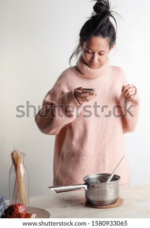 Pretty girl reading a recipe online and trying to cook. 