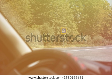 Pedestrian crossing sign through car glass on nature background